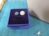 a pair of earrings sitting in a box on a table