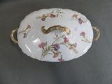 a white plate with a gold handle and flowers on it