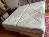 a bed with two mattresses on it in a room