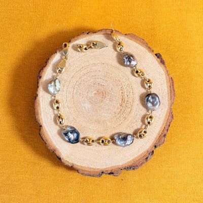 un bracelet composé de perles et de chaînes en or sur fond jaune