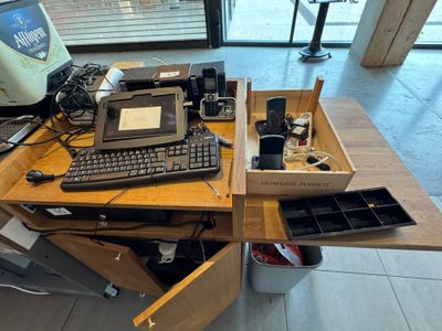 a desk with a laptop, keyboard, mouse, and other items on it