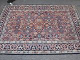 un tapis posé par terre, avec un chat assis à côté