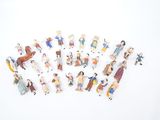 de nombreuses petites figurines représentant des personnes sur une surface blanche