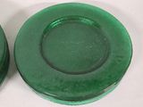 two green glass plates sitting on a white surface