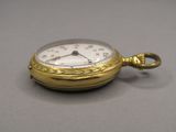 une montre de poche en or à laquelle est accrochée une chaîne