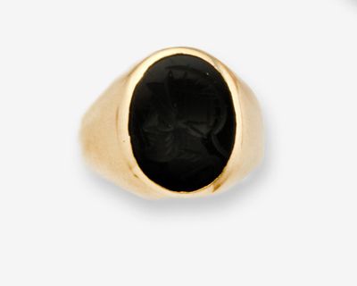 gros plan d'une bague en or avec une pierre noire