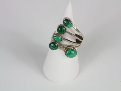 silver ring with green glass beads on a white cone