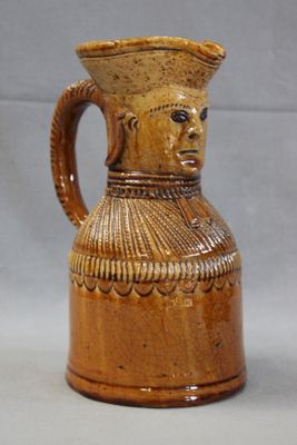 a brown vase with a face on it