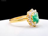 an image of a close up of a gold ring with a green stone