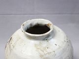 a white vase with a brown rim sitting on a table