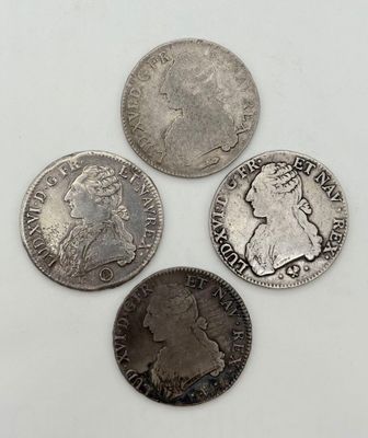 quatre types différents de pièces d'argent sur une surface blanche