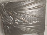 une boîte emballée dans du plastique posée sur une surface blanche