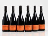 six bouteilles de vin sont alignées sur une surface blanche