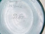 a blue vase with writing on it sitting on a table
