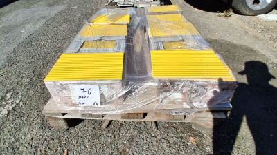 une palette sur laquelle sont posées de nombreuses boîtes, posée à même le sol