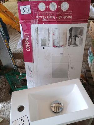 un lavabo blanc posé devant un carton posé par terre