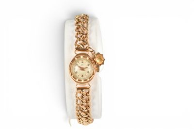 an image of a gold wrist watch with a chain around it
