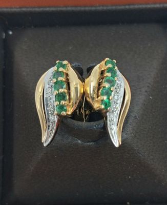 un gros plan sur une paire de boucles d'oreilles ornées de pierres vertes