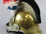 a gold helmet with a red, white, and blue pom pom on it