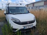 a small white van parked in a field of tall grass