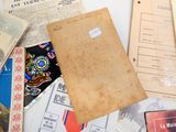 une pile de vieux papiers posée sur une table où se trouvent de nombreux autres papiers
