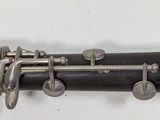 a close up of a clarinet that is on a white surface