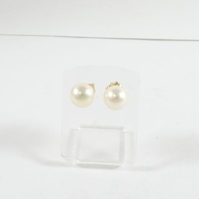 une paire de boucles d'oreilles en perles posée sur une vitrine transparente