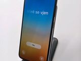 a close up of a phone on a stand on a white surface