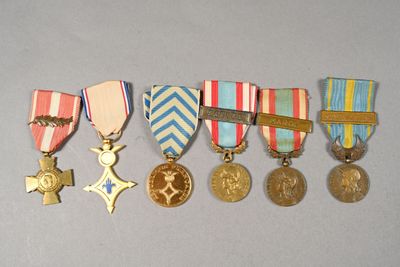 five medals and a cross on a white surface