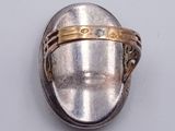 a silver ring with a gold band on it