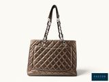 a woman ' s handbag with a chain strap and a quilted design