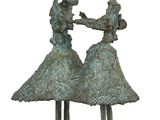 bronze sculpture of two women dancing on a white background