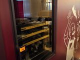 une cave à vin placée contre un mur sur lequel est accroché un tableau