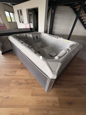 une photo d'une salle de bains avec une baignoire jacuzzi au milieu de la pièce