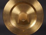 an image of a gold plate on a stand against a black background