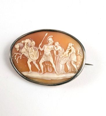 une photo d'une broche sur laquelle figure l'image d'un groupe de personnes