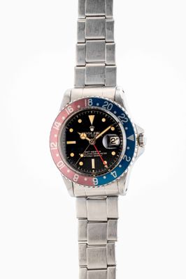 an image of a wrist watch with a red, blue and yellow bezel