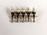 three gold and black pins with pearls on them sitting on a white surface