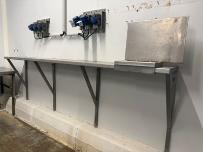 une photo d'une pièce avec une table sur laquelle se trouve un ordinateur portable