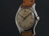 a close up of a wrist watch with a brown leather strap