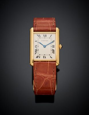 an 18k yellow gold cartier tank watch with brown leather strap