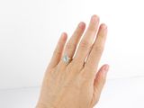 a woman ' s hand with a diamond ring on it