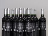 six bouteilles de vin sont alignées sur une table