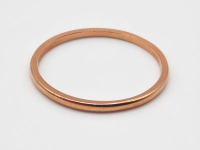 gros plan d'une bague en or sur une surface blanche