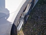the tire of a white car with a flat tire on the side of the road