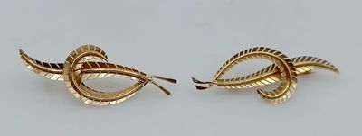 two gold tone earrings with twisted leaves on them