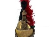 a gold helmet with a red feather on top of it
