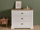 a white chest of drawers in a room with green walls