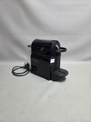 une machine à café noire posée sur une table blanche