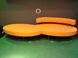 un canapé orange posé sur un sol vert dans une pièce